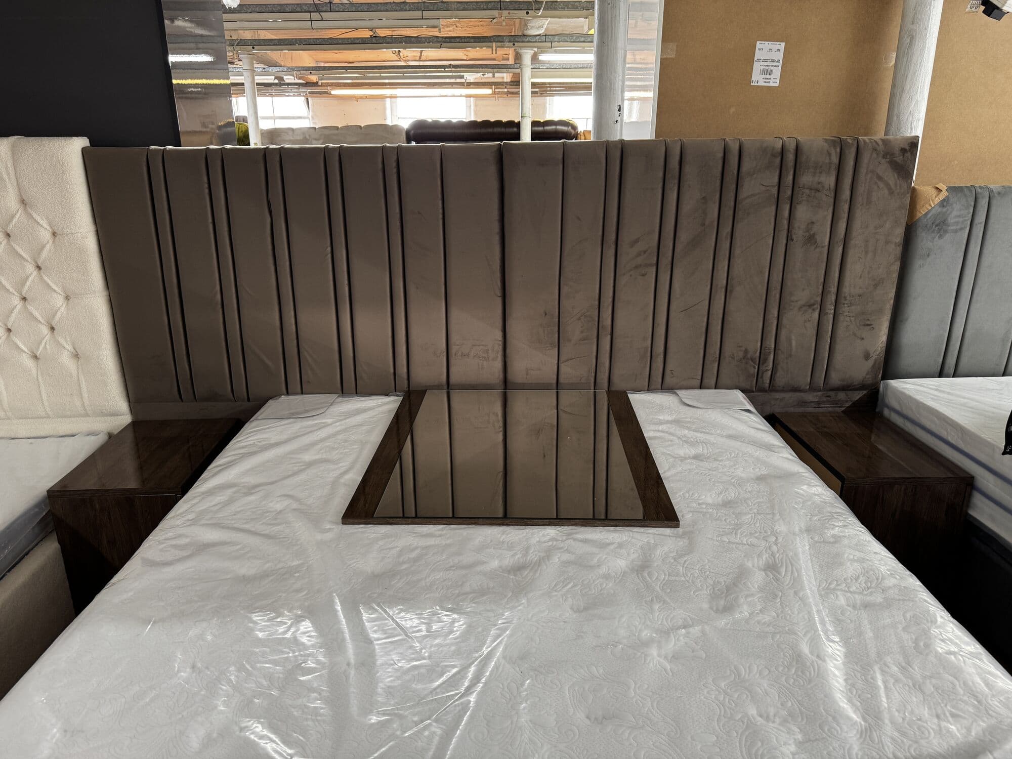 Super king bed with a wide vertical panel headboard and floating bedsides
