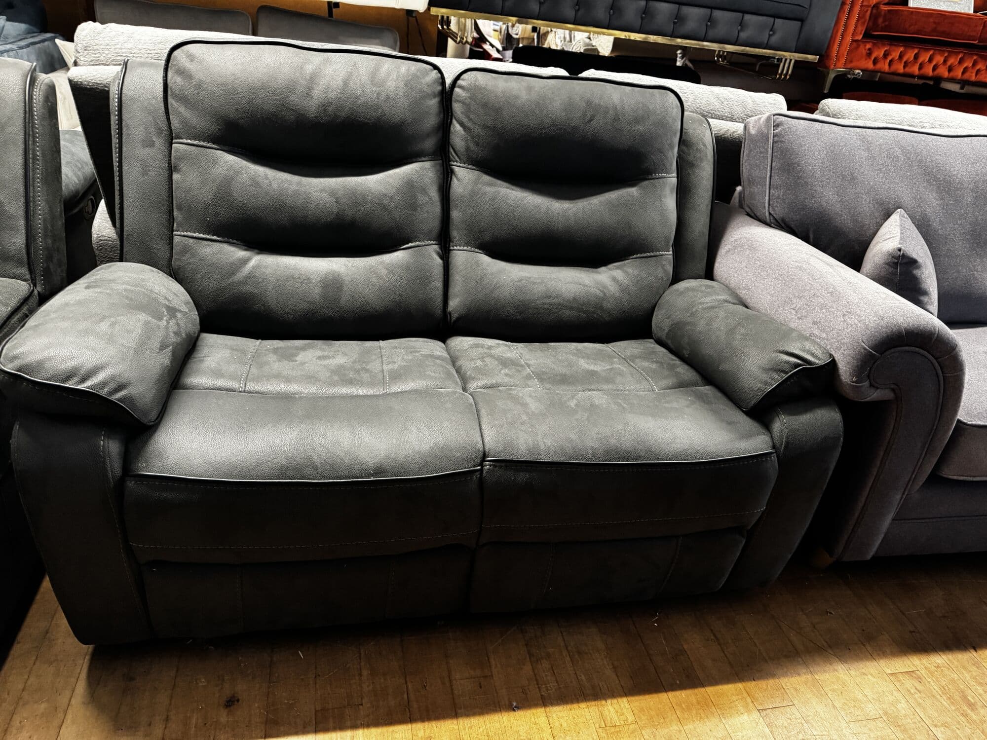 Grey two seater recliner sofa with contrast piping